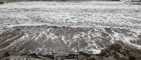 A rocky shoreline with waves crashing onto the beach.