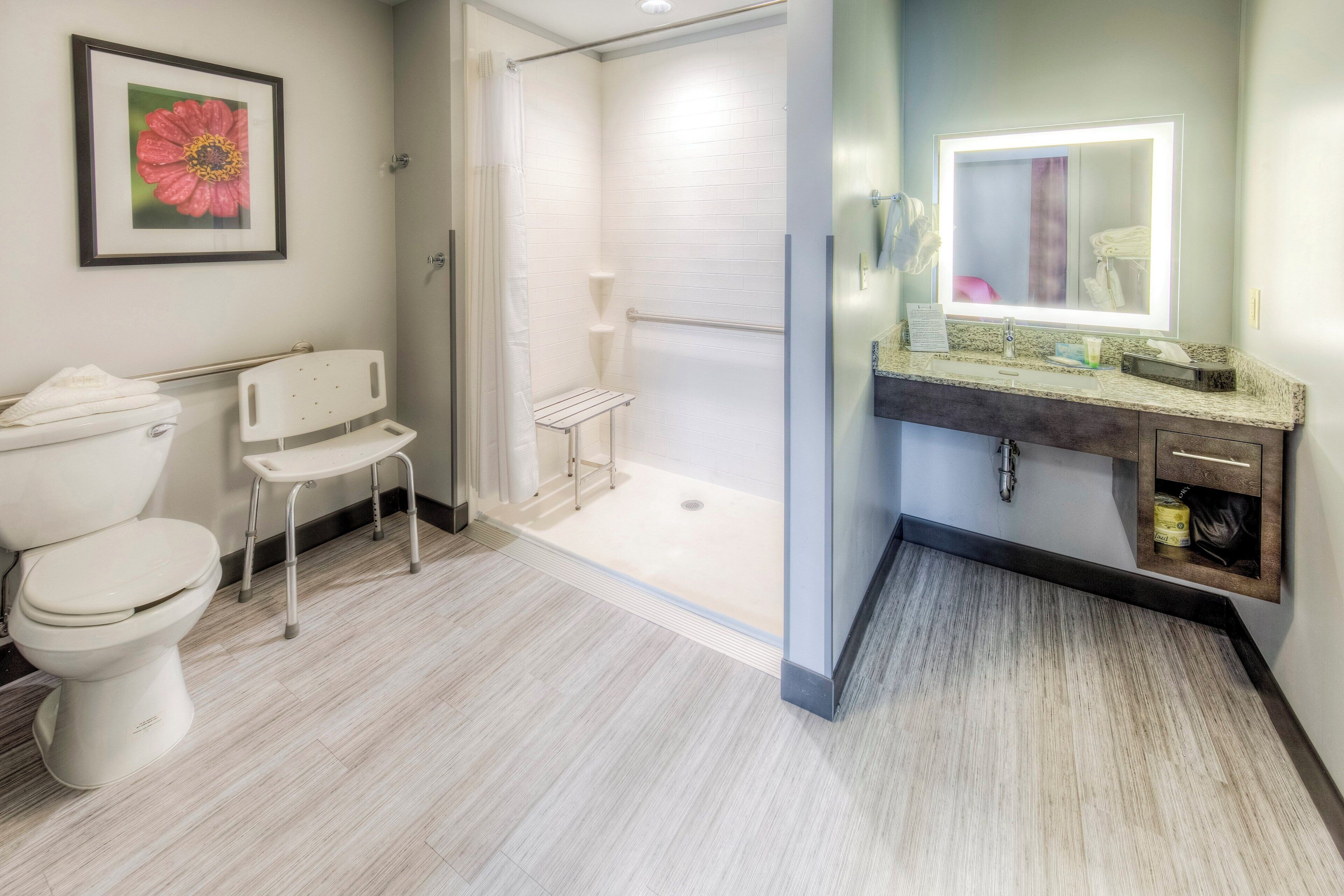 A modern bathroom with a toilet, shower, and sink.