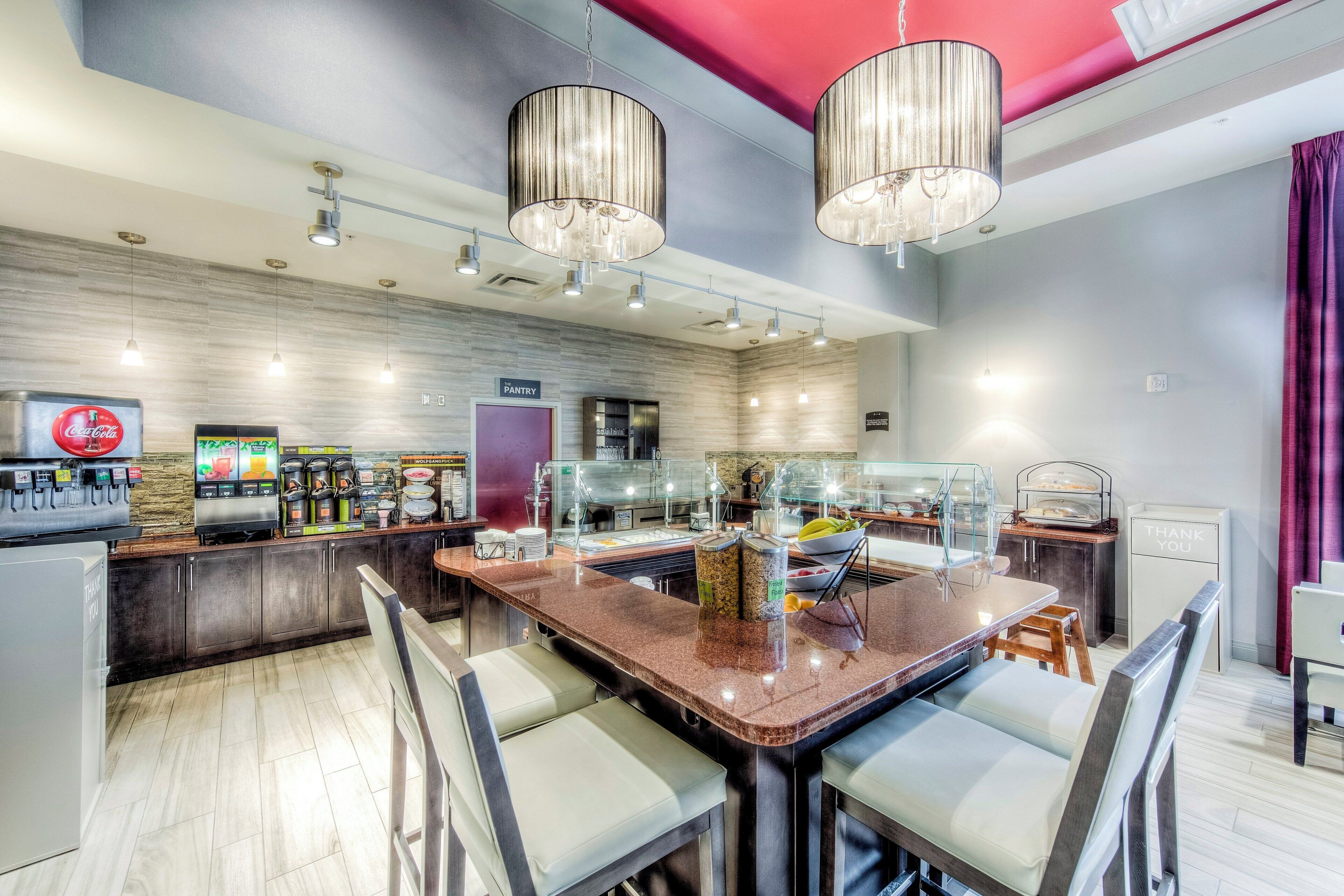 A modern restaurant with a bar area, seating, and a counter with food and drink options.