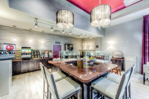 A modern restaurant with a bar area, seating, and a counter with food and drink options. - Staybridge Suites Columbus Univ Area - OSU by IHG (Columbus)