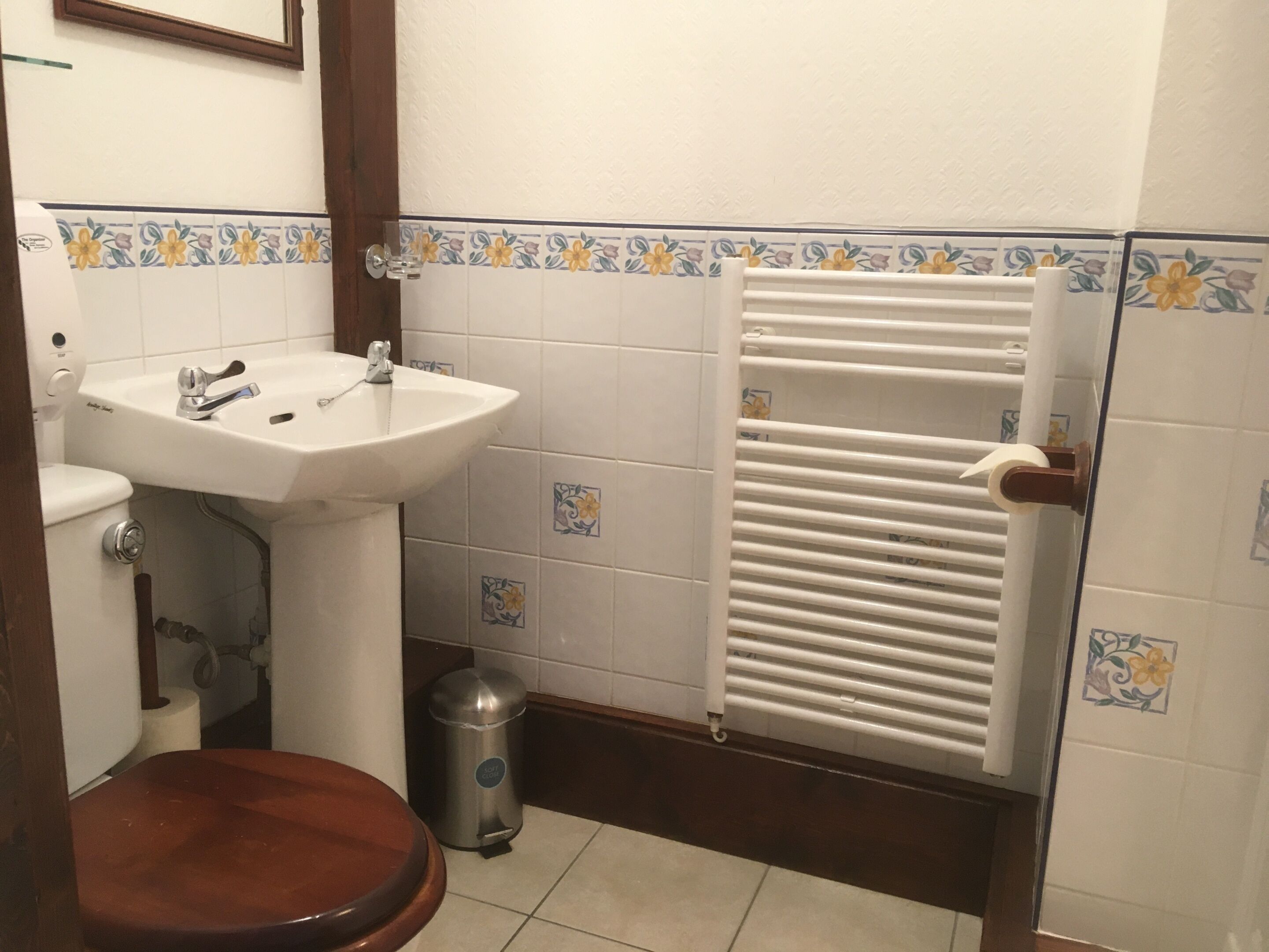 A bathroom with a white sink, toilet, and radiator.