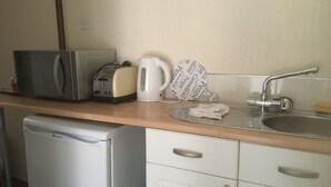 Une petite cuisine équipée d’un grille-pain, d’une bouilloire et d’un évier.