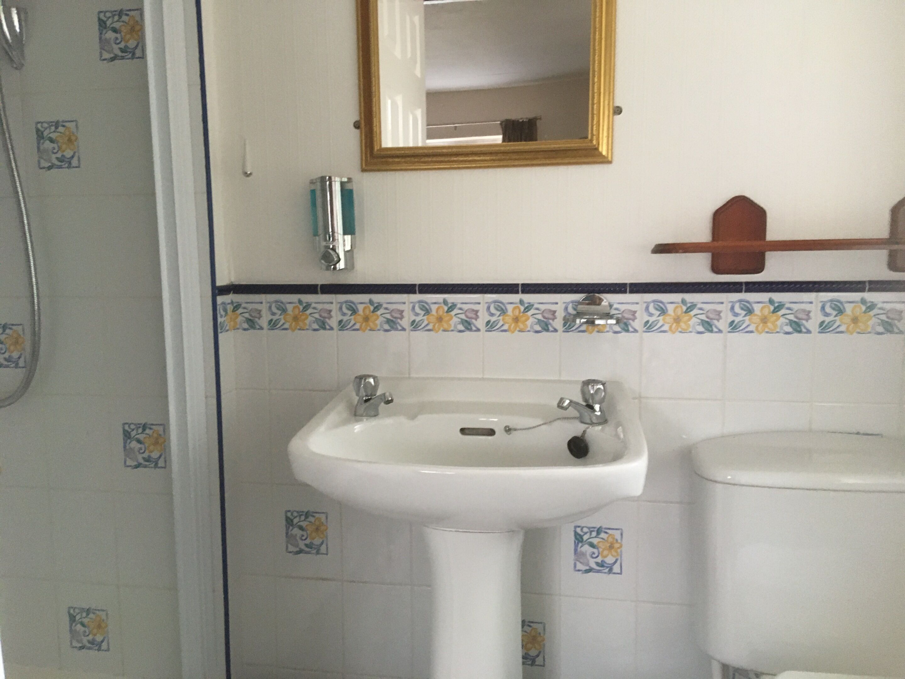 Un baño con un lavabo blanco, un espejo y un inodoro.