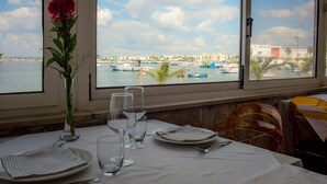 Ein Esstisch mit Blick auf den Hafen und die Boote.