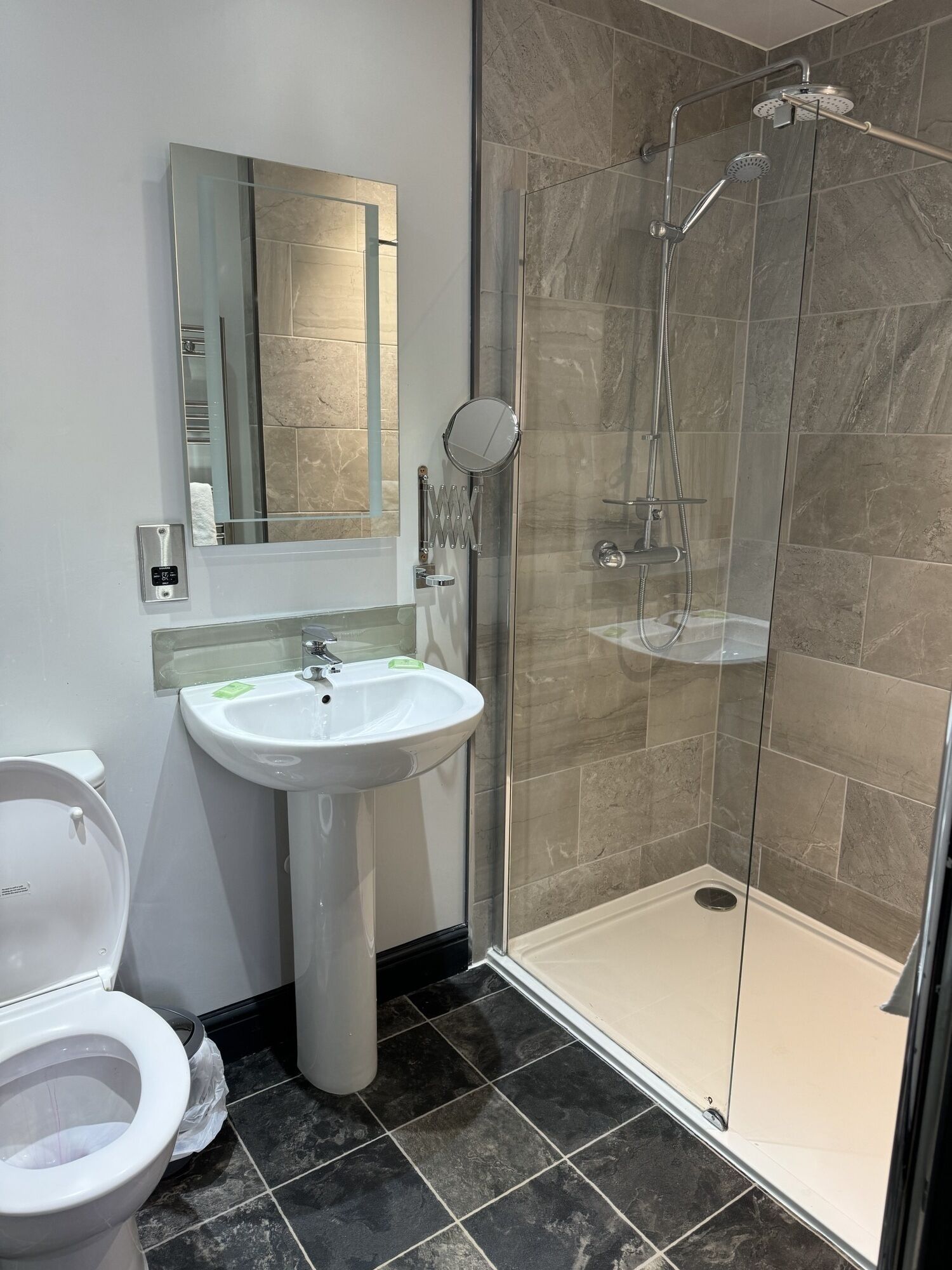 A bathroom with a white sink, a toilet, and a glass-enclosed shower area.