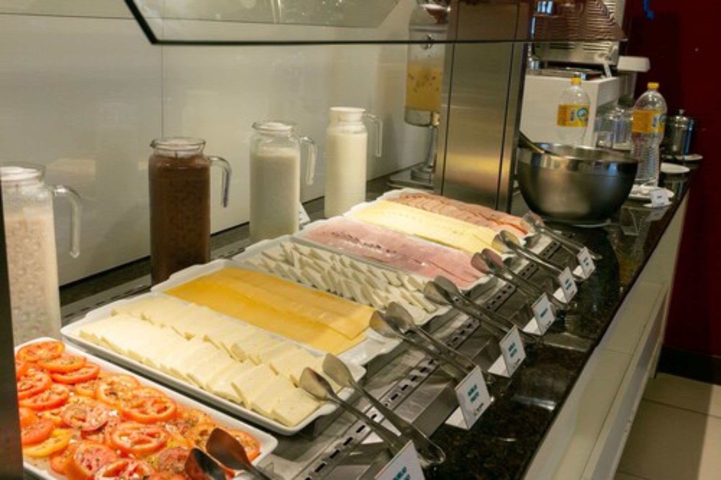 A buffet with various food items and condiments.