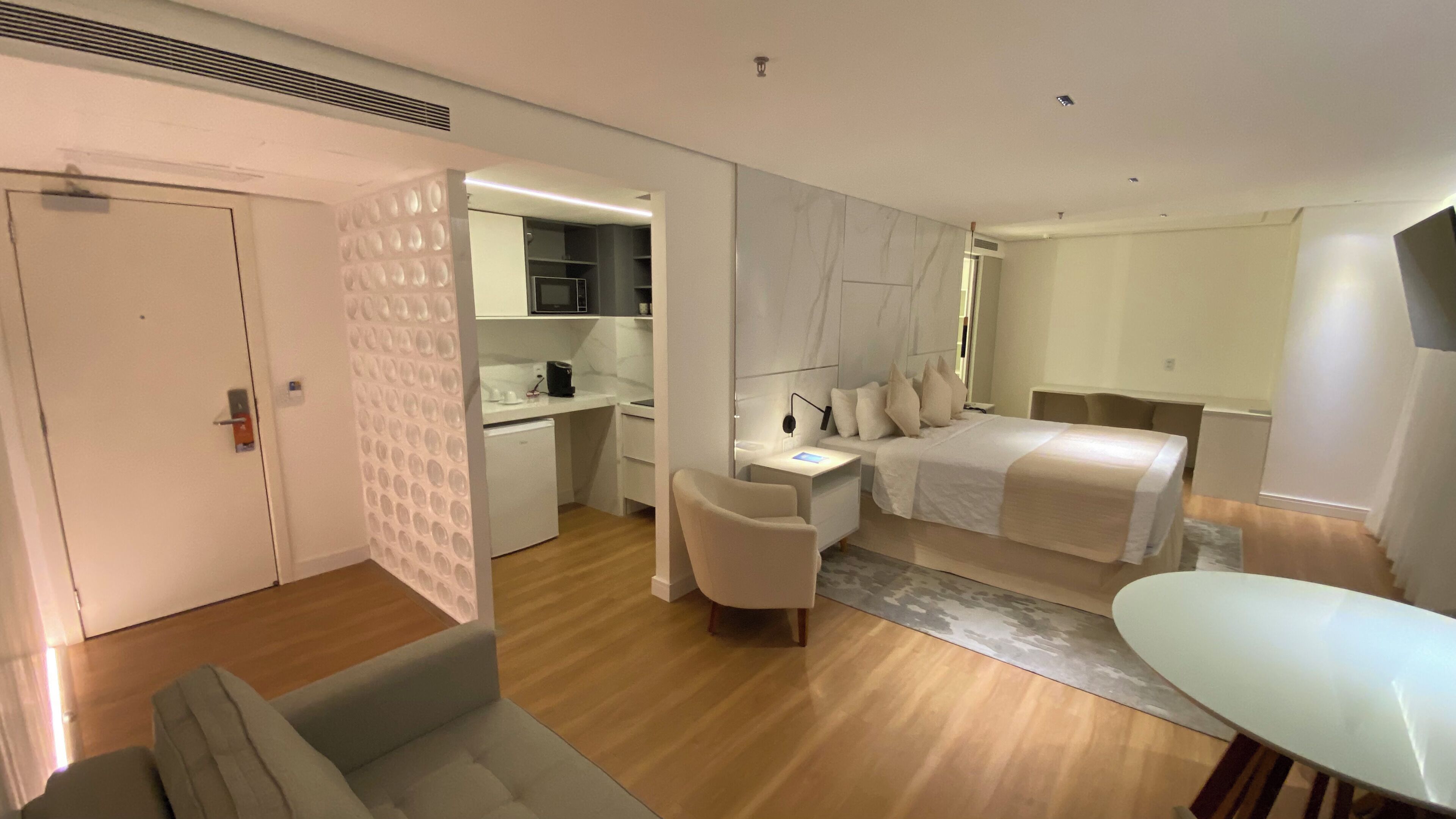 Une chambre d’hôtel moderne équipée d’un lit, d’un bureau, d’une chaise et d’une table à manger.