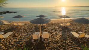 A beach with sun umbrellas and lounge chairs. - Iolida Beach by Smile Hotels (Chania)