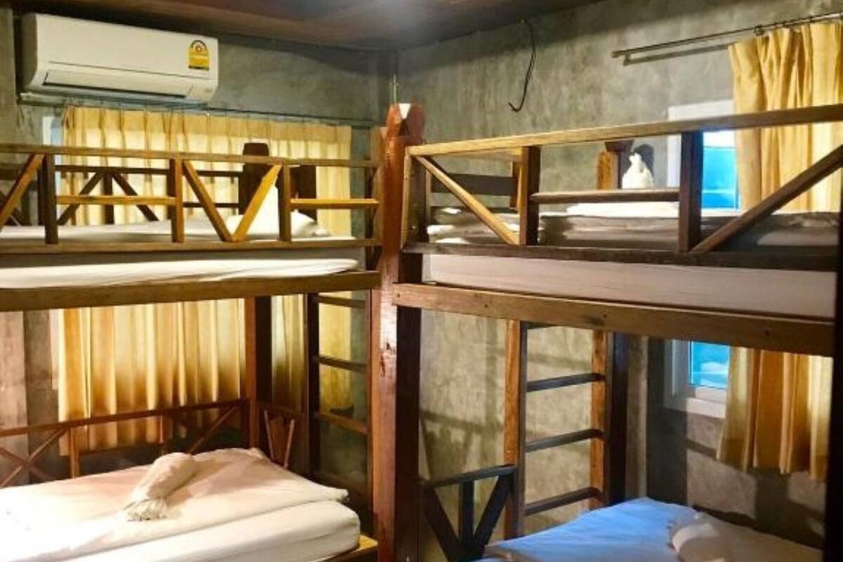 Ein Schlafraum mit Etagenbett, Holzwangen und einem Einzelbett.