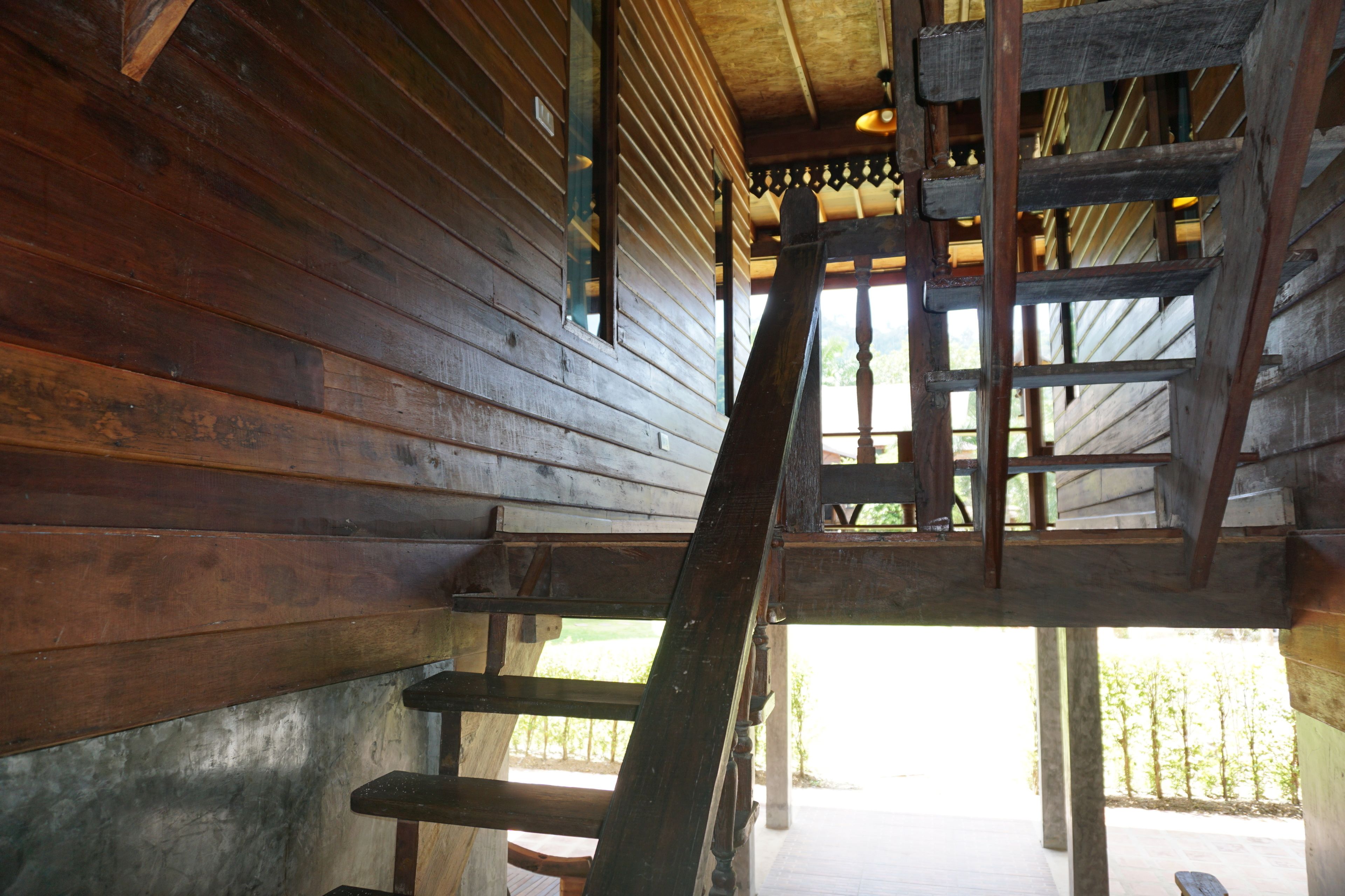 Eine Holztreppe führt zu einer oberen Ebene mit Blick ins Freie.