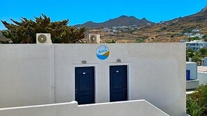 Un edificio con fachada blanca, dos puertas oscuras y un logotipo con diseño azul y amarillo.