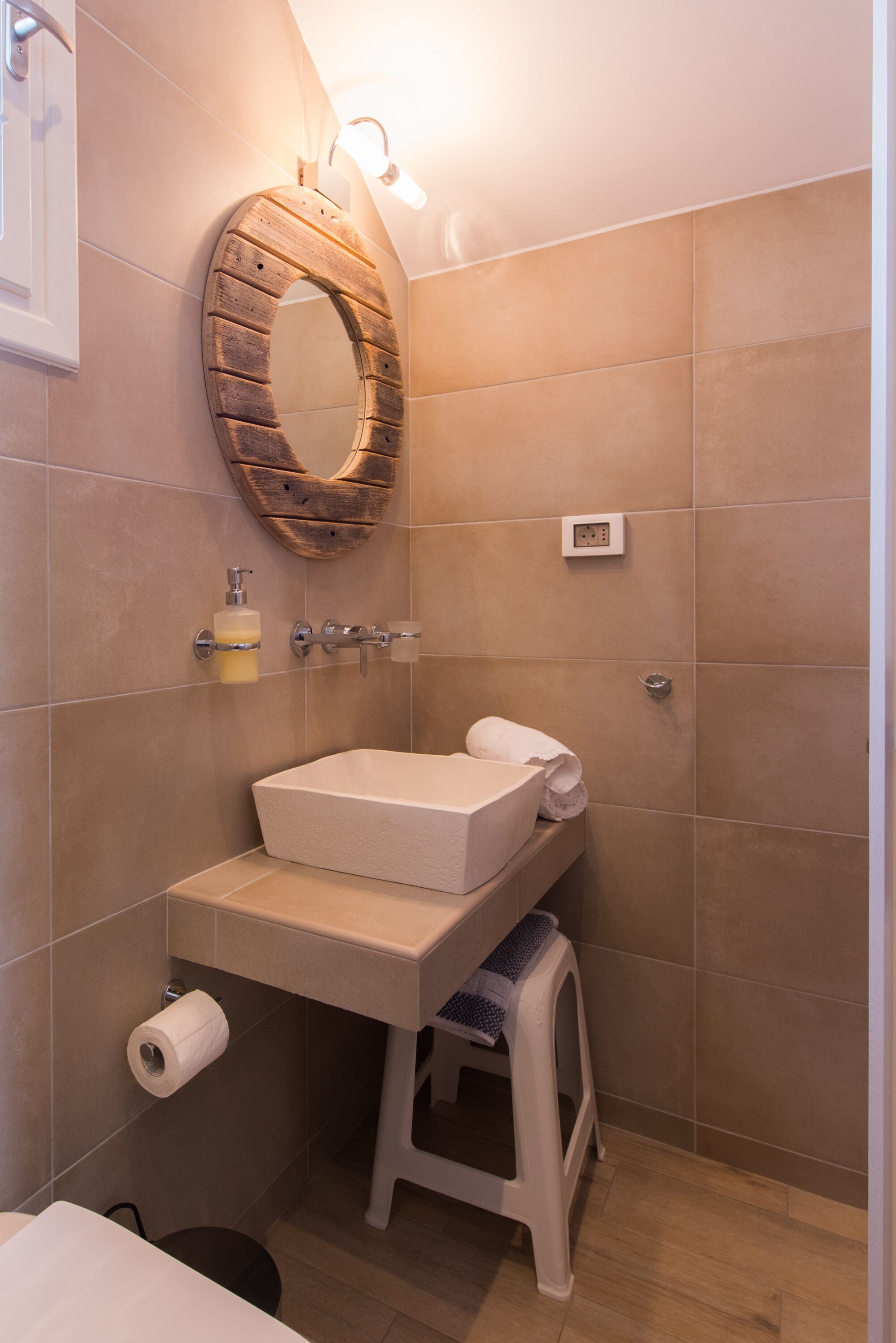 Ein Badezimmer mit einem spiegelnden Holzbettrahmen, einem Waschbecken mit Handtuch und einer Toilette.
