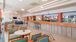 A hotel lobby with a bar area, seating arrangements, and a television screen. - Amfora (Labin)