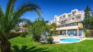 A modern building with multiple balconies, a swimming pool, and lush greenery. - Amfora (Labin)