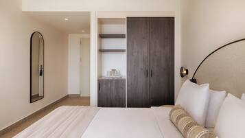 Un dormitorio con cama, armario, espejo y mesita de noche.