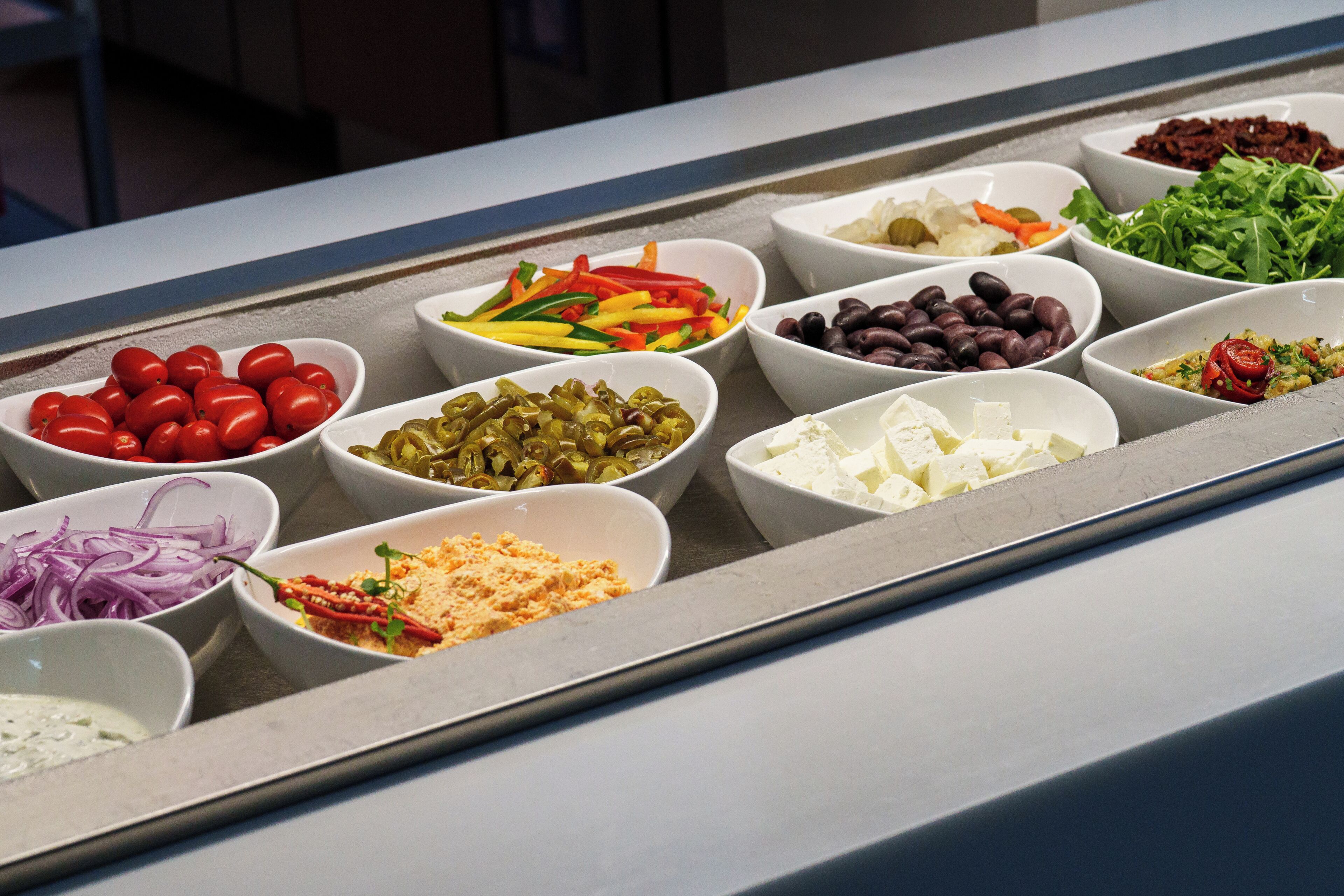 Un bufé con diversos alimentos servidos en recipientes.