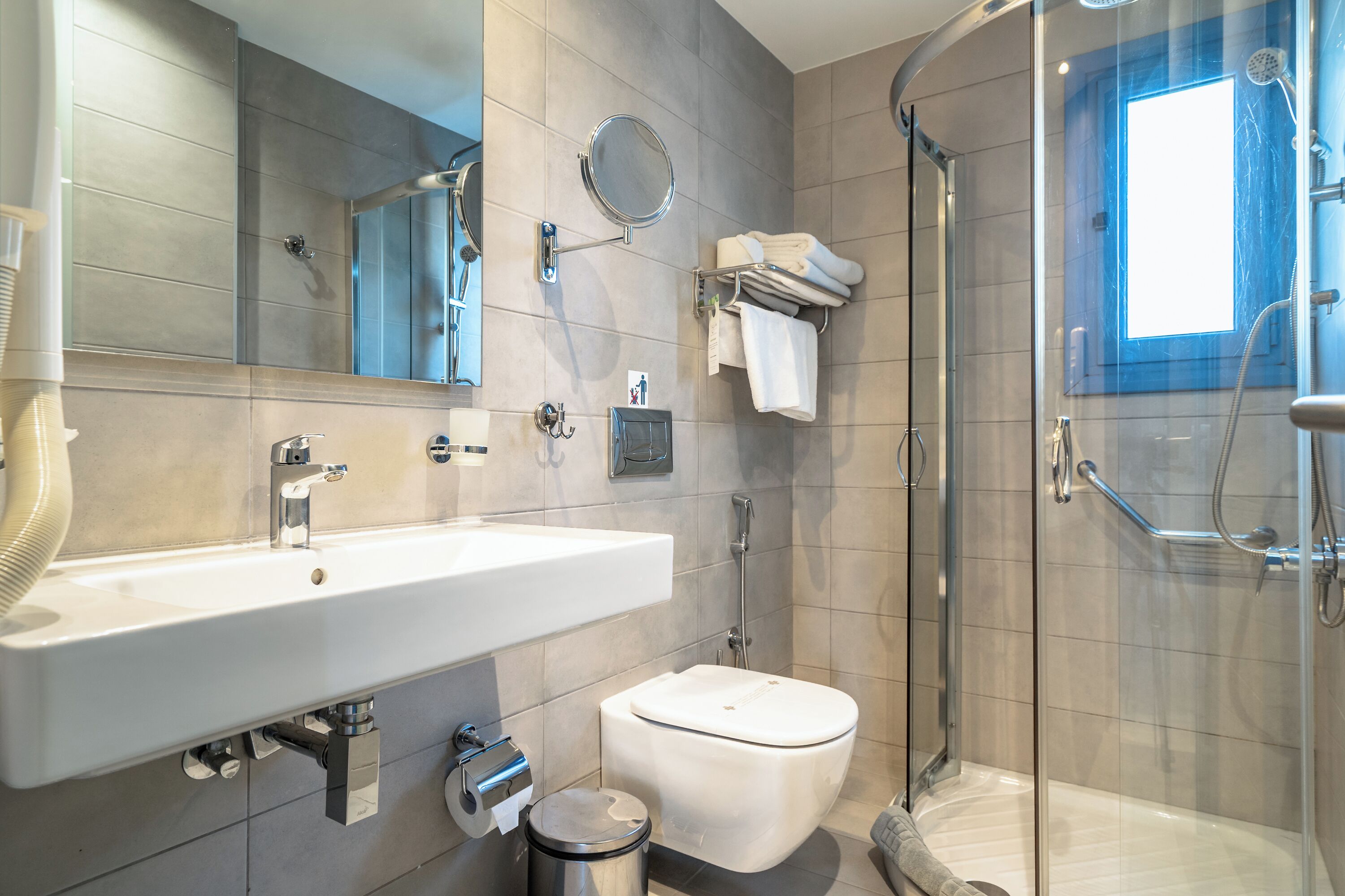 A modern bathroom with a sink, toilet, and glass-enclosed shower.