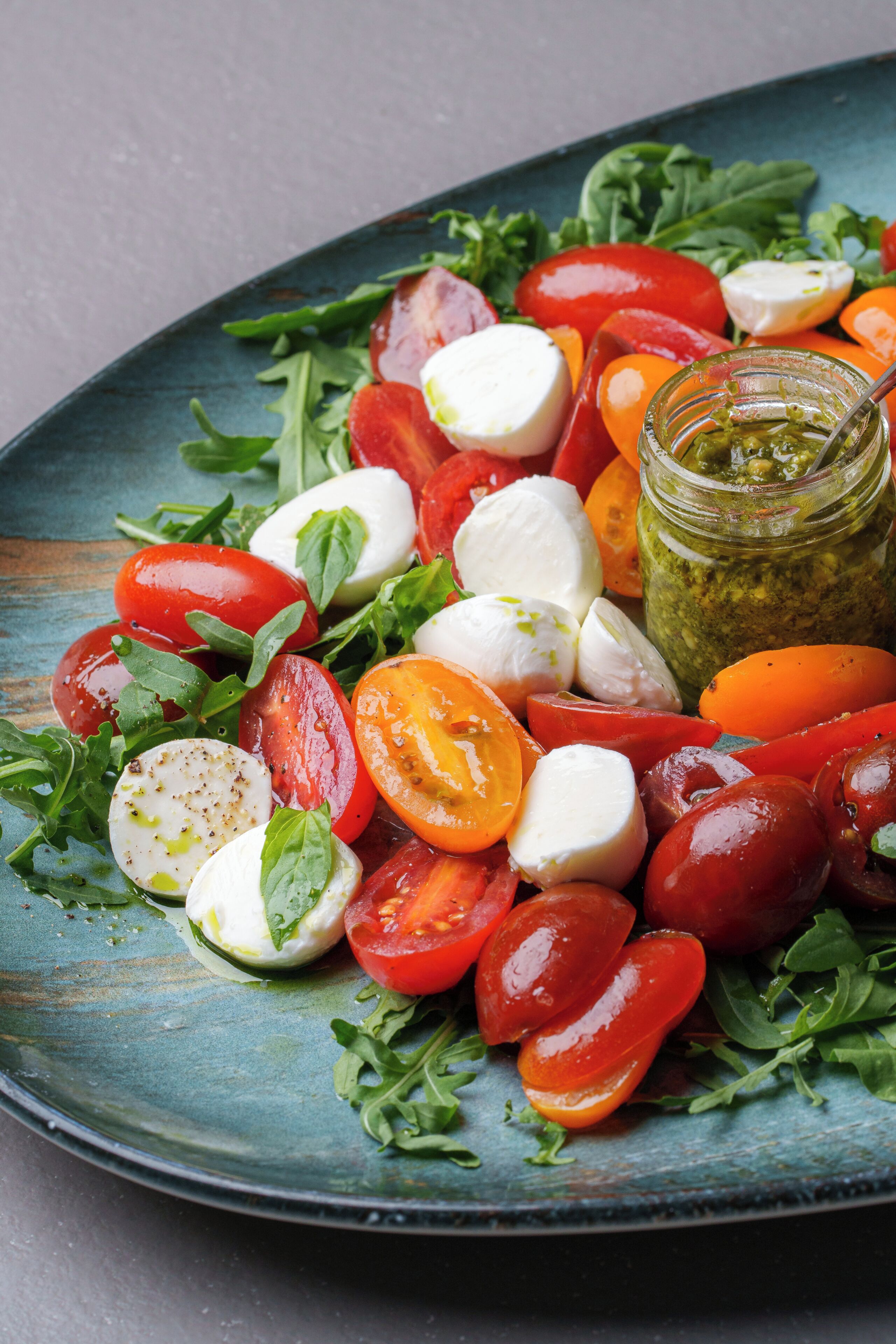 A plate of fresh salad with tomatoes, mozzarella, and basil.