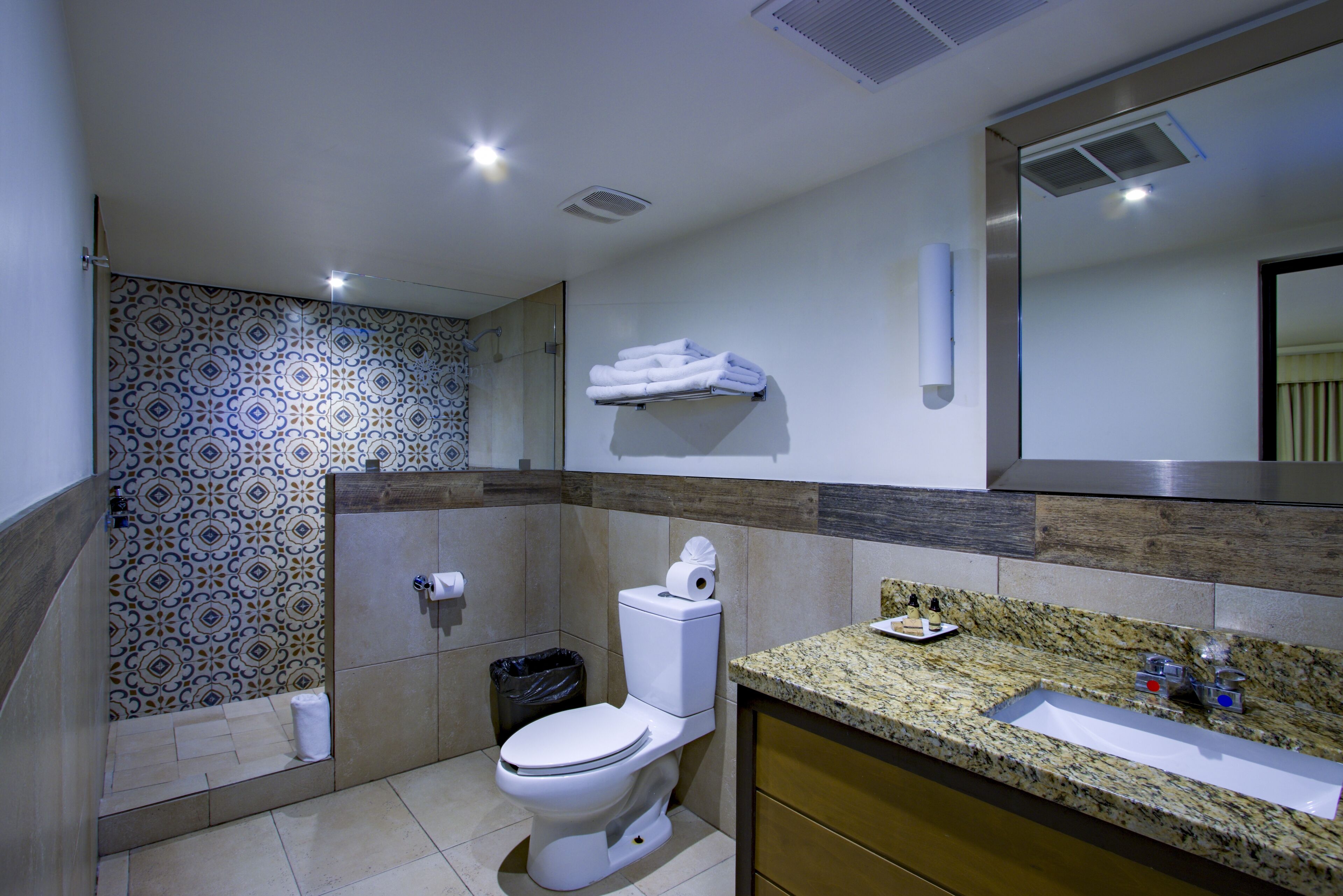 A modern bathroom with a toilet, sink, and shower.