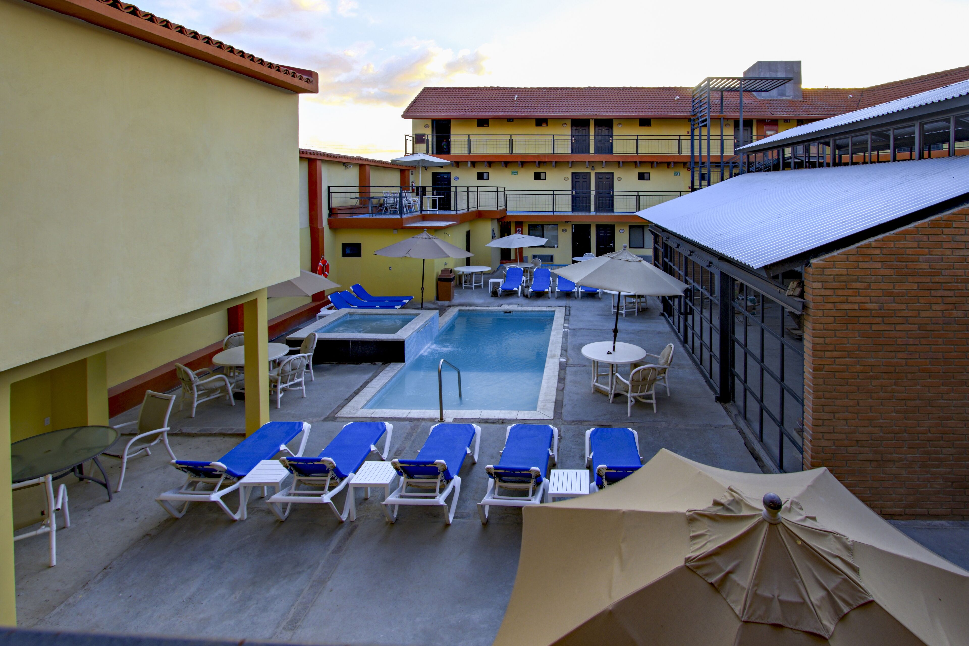 Alberca al aire libre, sombrillas en la alberca y camastros 