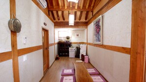 A hallway with wooden beams, a bench, and a microwave. - Happiness Full Guesthouse (Jeonju)
