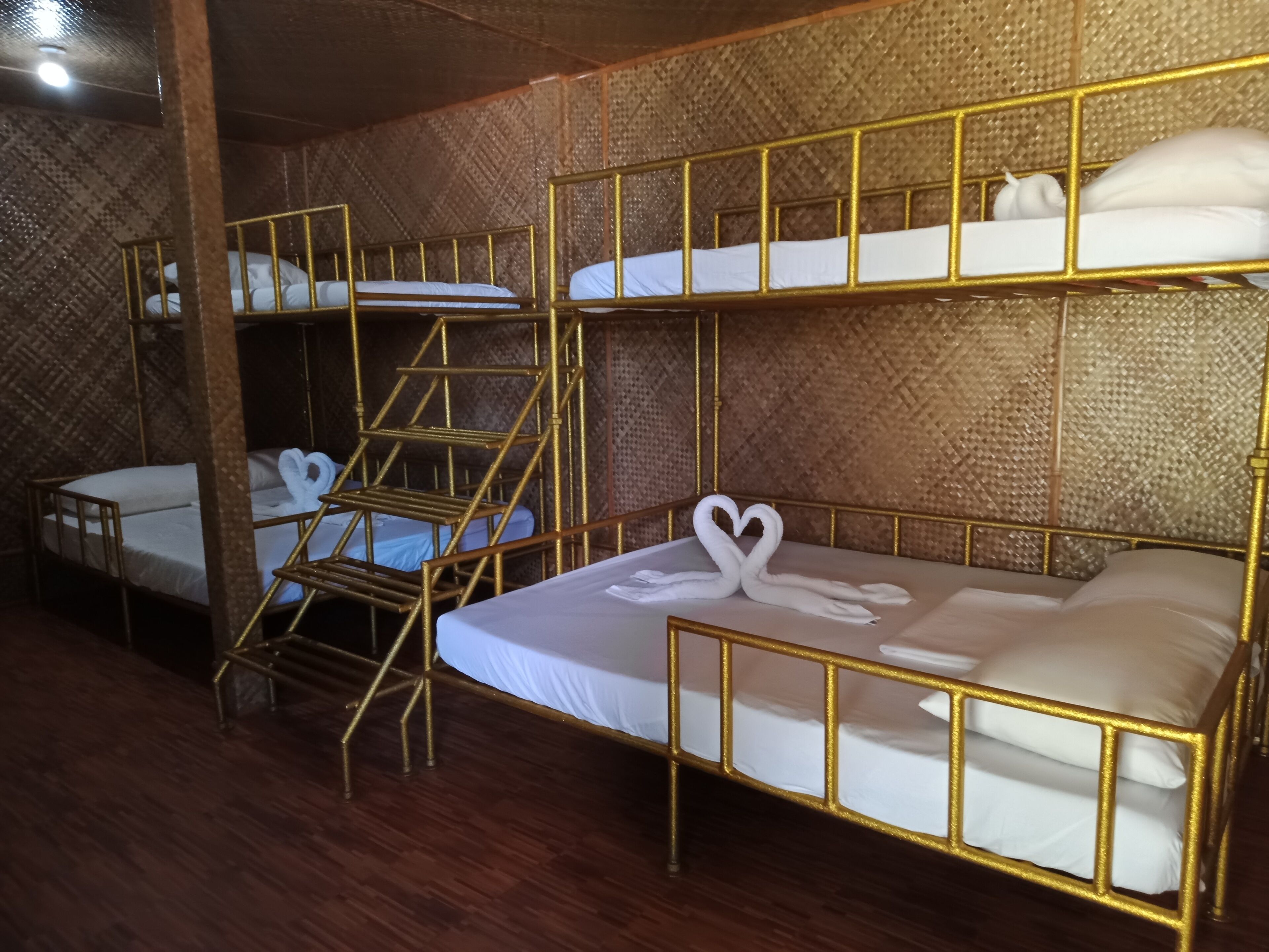 Habitación con literas, suelo de madera y pared con textura.