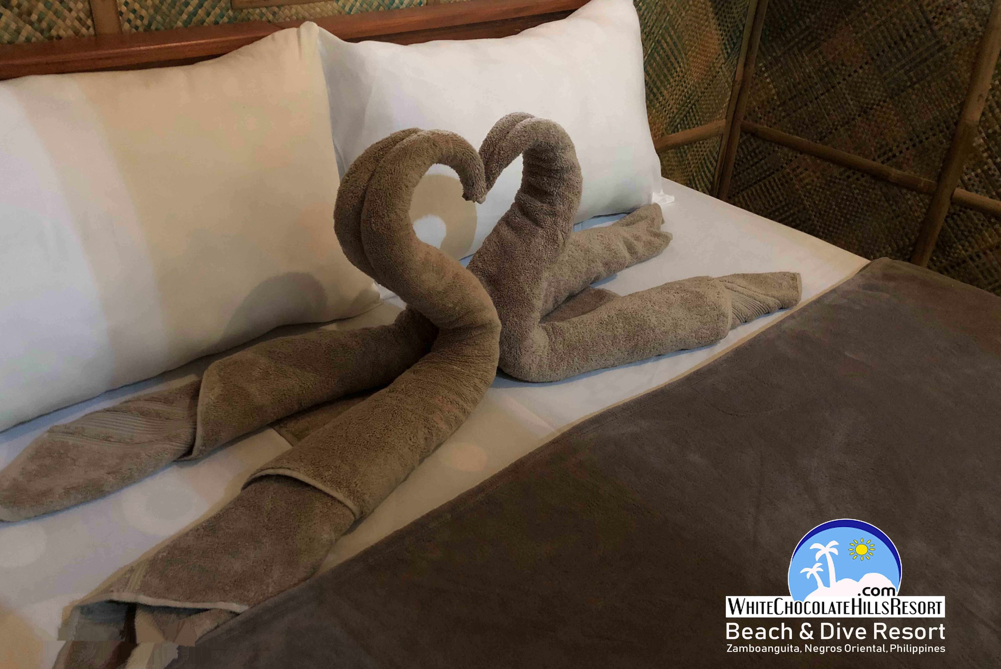 A bed with a swan-shaped towel arrangement.
