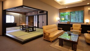 A traditional Japanese room with tatami flooring, a low table, and cushions. - Tsukagoshiya (Shibukawa-shi)