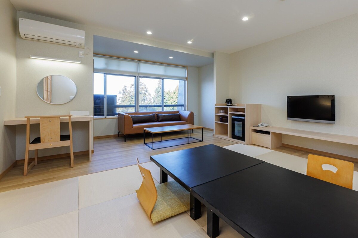 A modern living room with a sofa, TV, and a dining table.