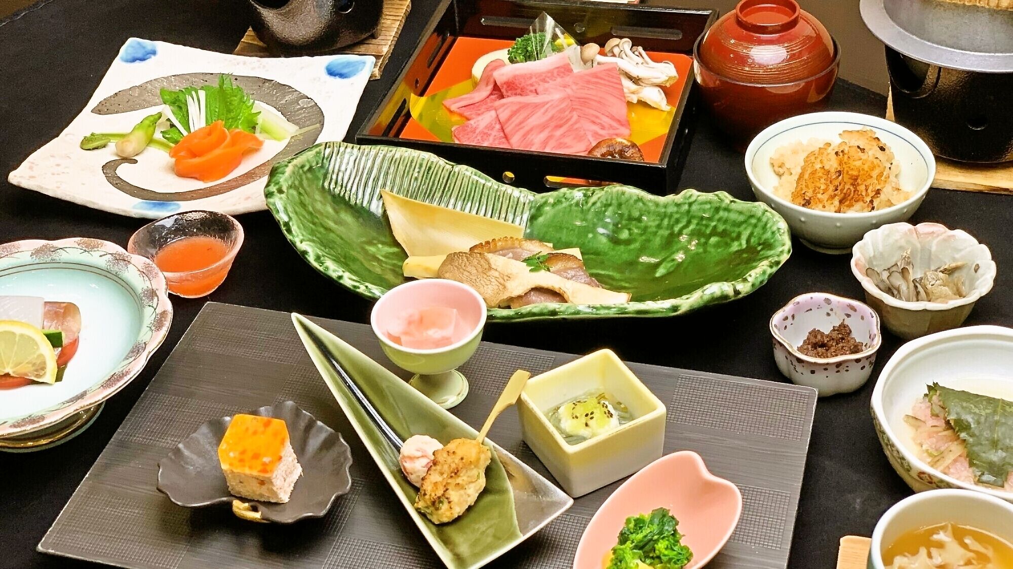 A variety of Japanese dishes on a table, including sashimi, sushi, and pickled vegetables.