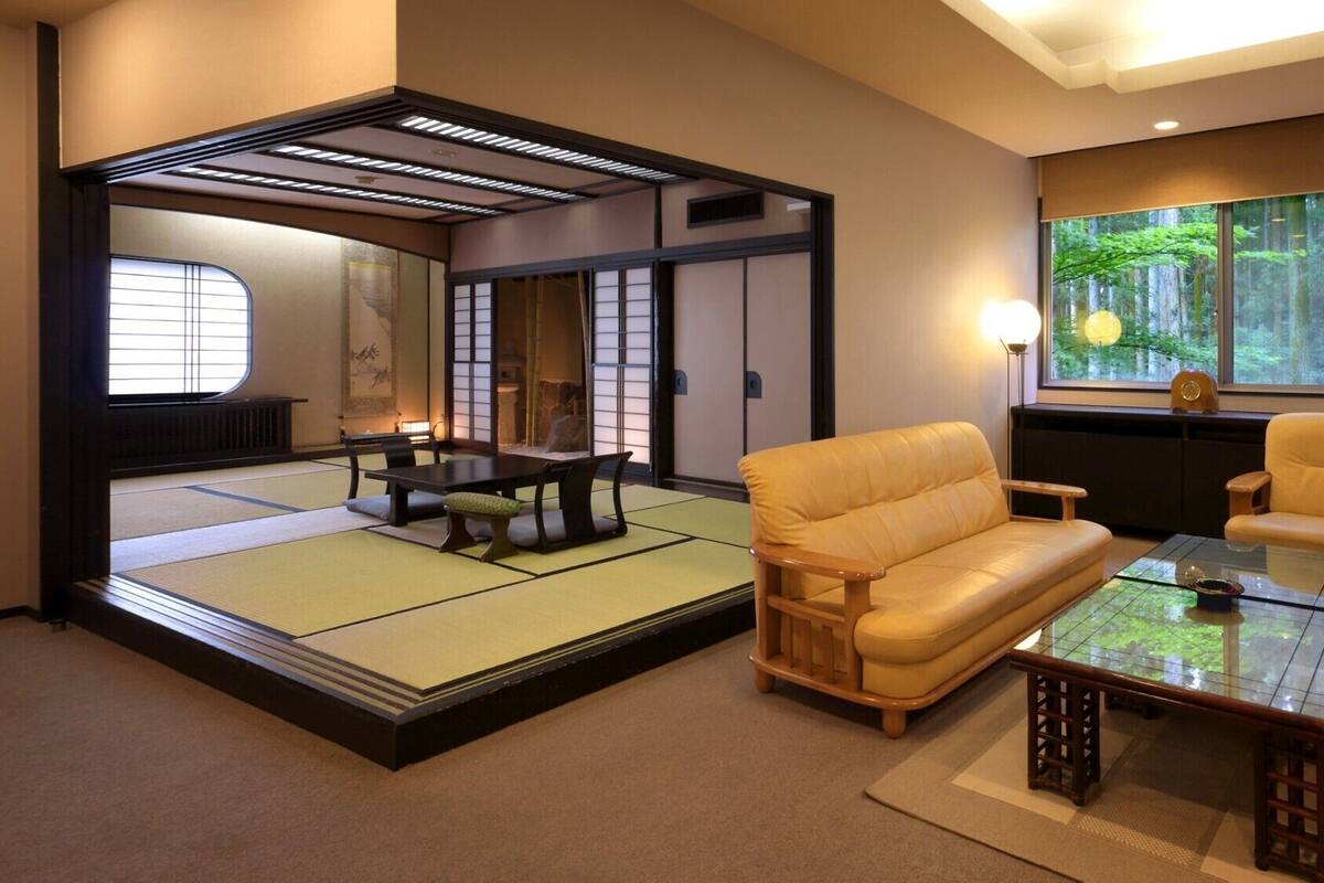 A traditional Japanese room with tatami flooring, a low table, and cushions.