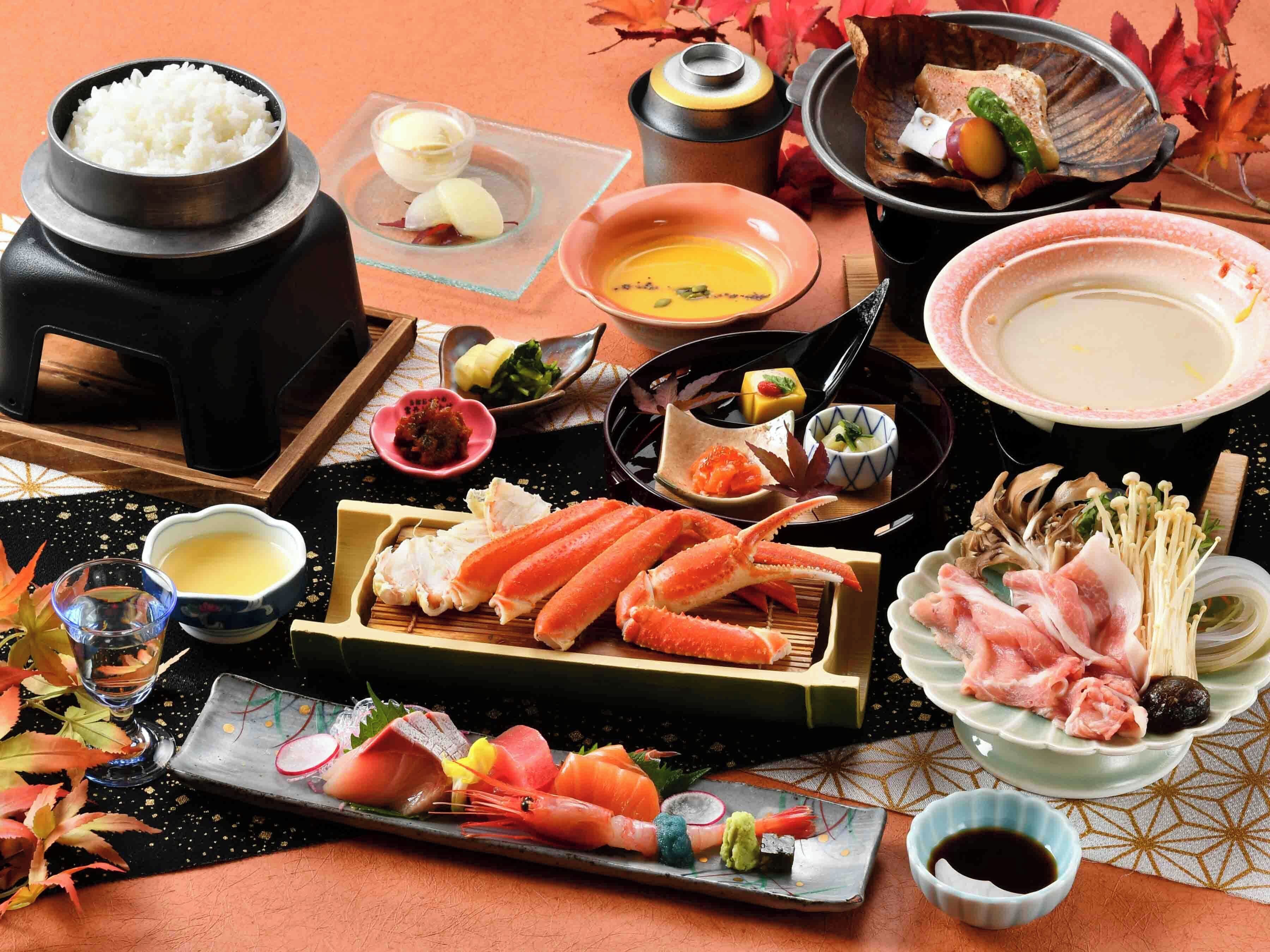 Una presentación tradicional de comida japonesa con diversos platos, como arroz, mariscos y sopa.