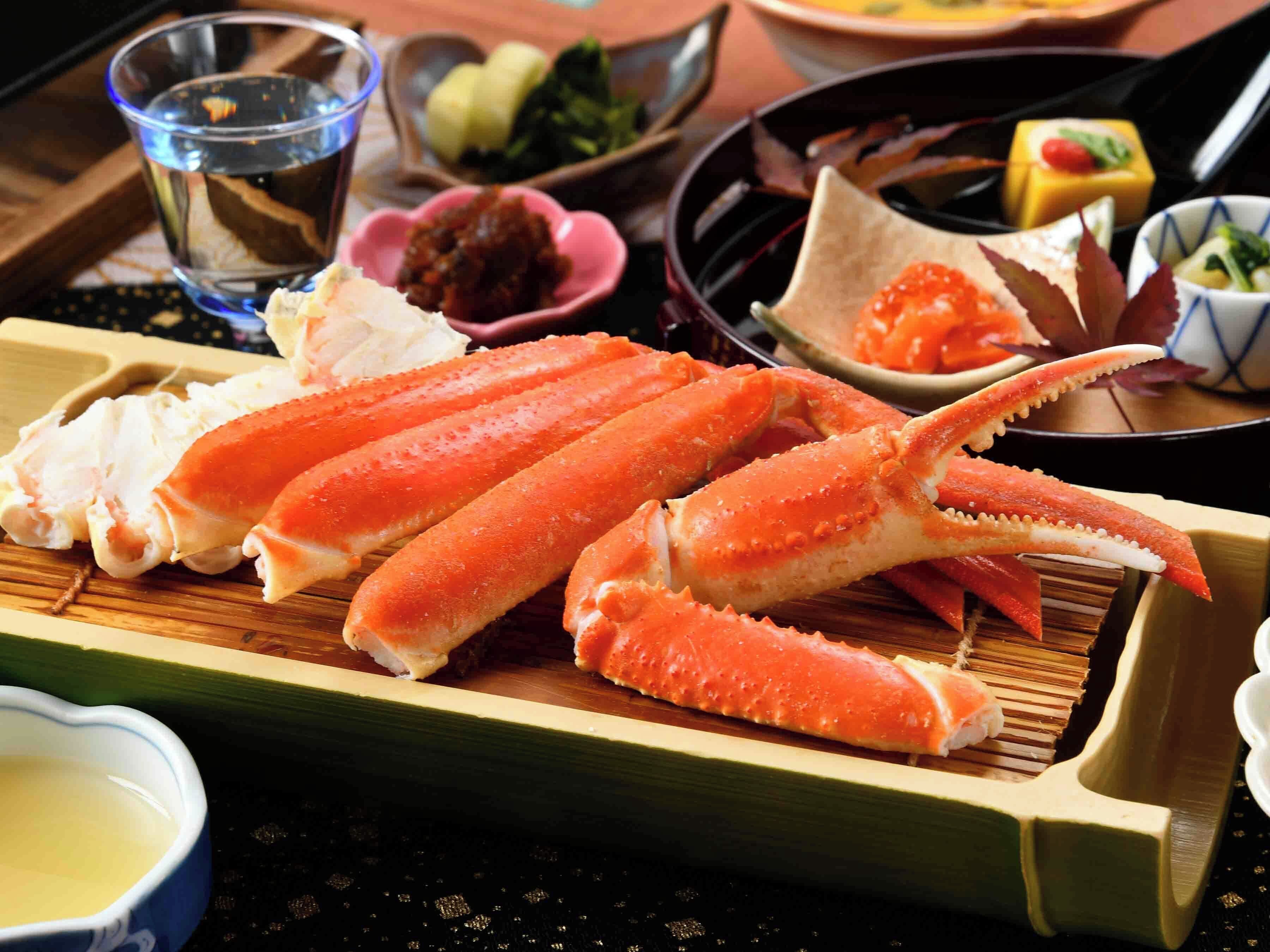 A wooden tray with several pieces of cooked crab legs.