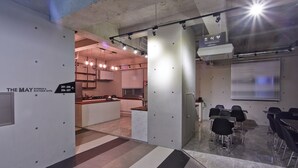 A modern conference room with a kitchen area, a reception desk, and directional signage. - Hotel The May (Gwangju)