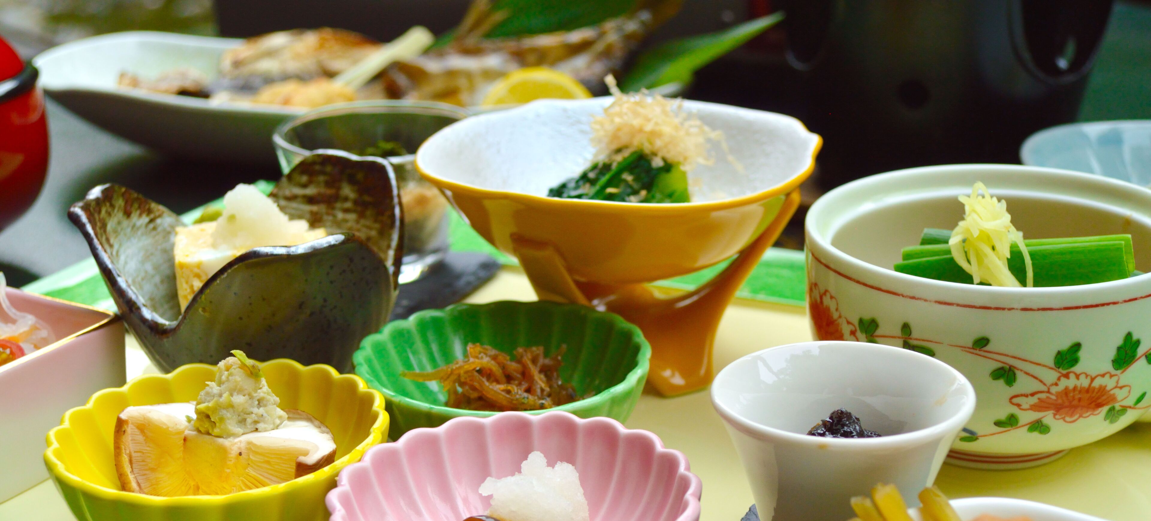 A variety of dishes in different colored bowls on a table.