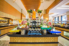Enjoy a sumptuous spread at our central buffet, featuring a variety of dishes on tiered stands.