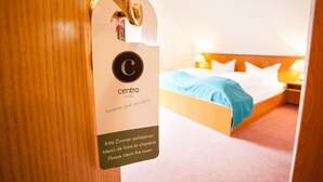 A hotel room with a bed, a nightstand, and a sign indicating the room number and a request to clean the room. - Hotel Alter Wolf (Wolfsburg)