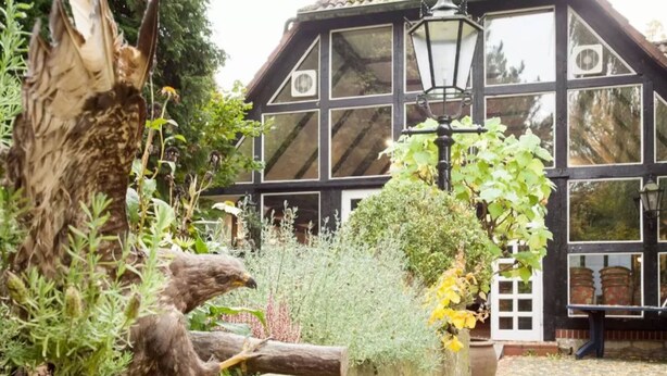 A traditional building with large windows and a stone pathway. - Hotel Alter Wolf (Wolfsburg)