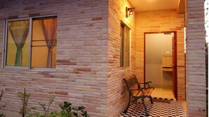 A brick exterior with a checkered floor, a bench, and a door leading inside. - Canal Resort (Sa Khu)