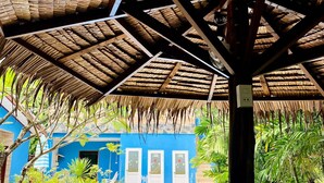 A covered outdoor area with a pool, blue walls, and potted plants. - Canal Resort (Sa Khu)