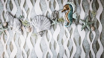Una pared decorativa con un diseño ondulado y diversos adornos con motivos marinos, como caracolas y un caballito de mar.