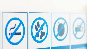 A row of signs with symbols indicating no smoking, no pets, no durian, and no cameras.