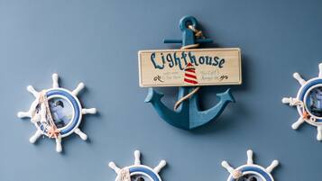 A nautical-themed decoration with a wooden sign reading "Lighthouse" and four ship's wheel ornaments.