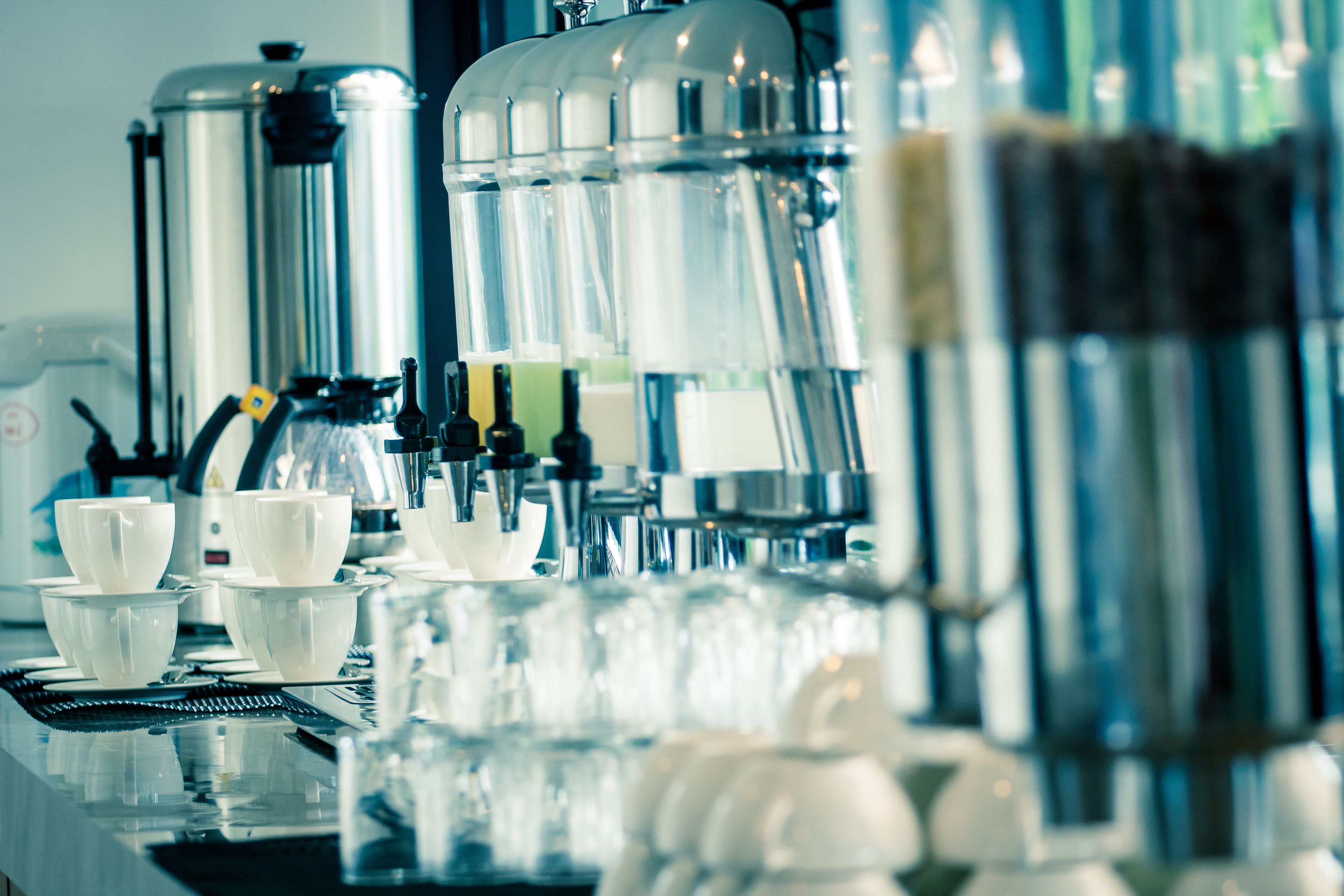 Une machine à café dotée de plusieurs distributeurs et de nombreux gobelets.