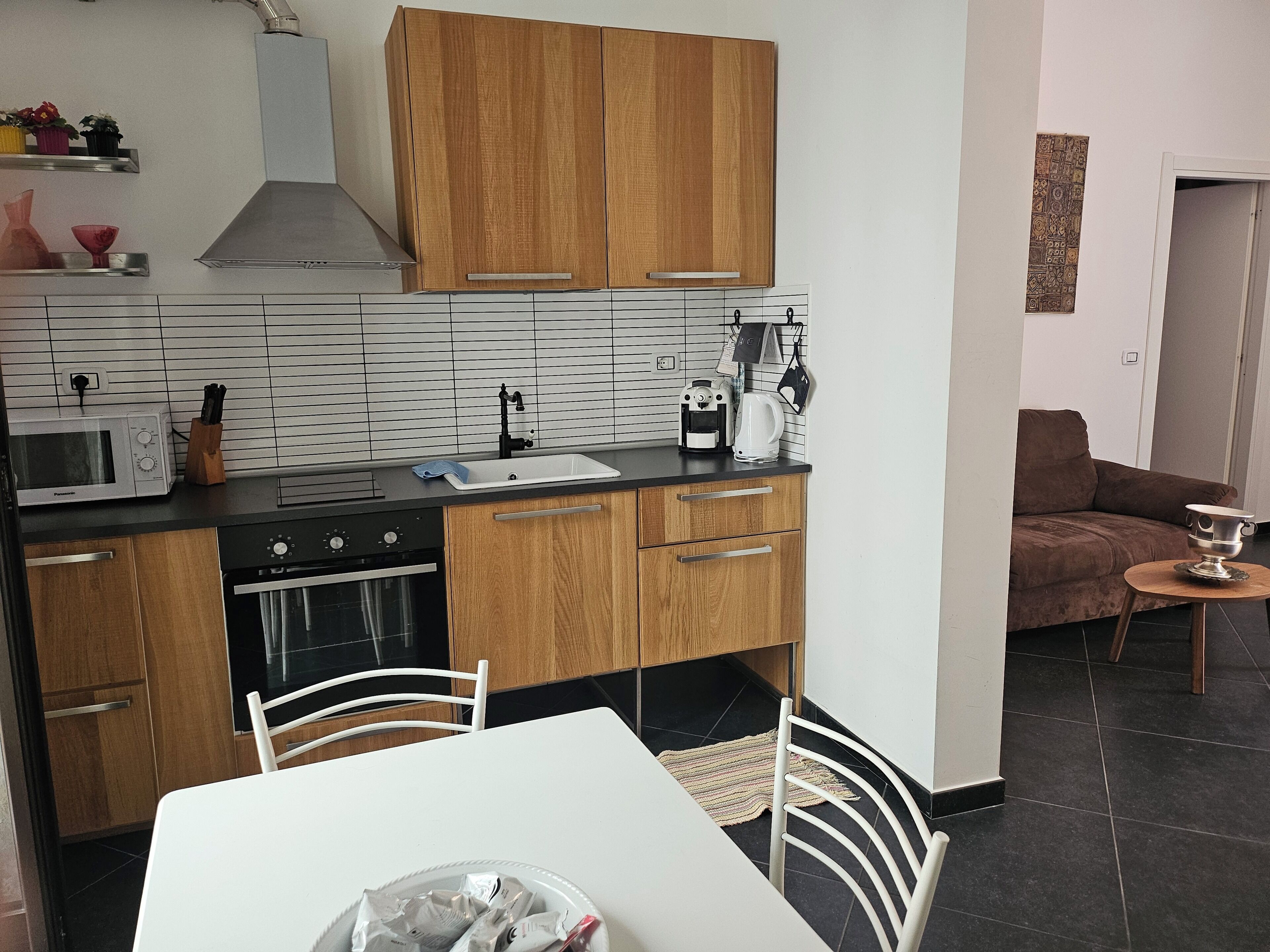 Uma cozinha compacta com micro-ondas, fogão, pia e armários de madeira.