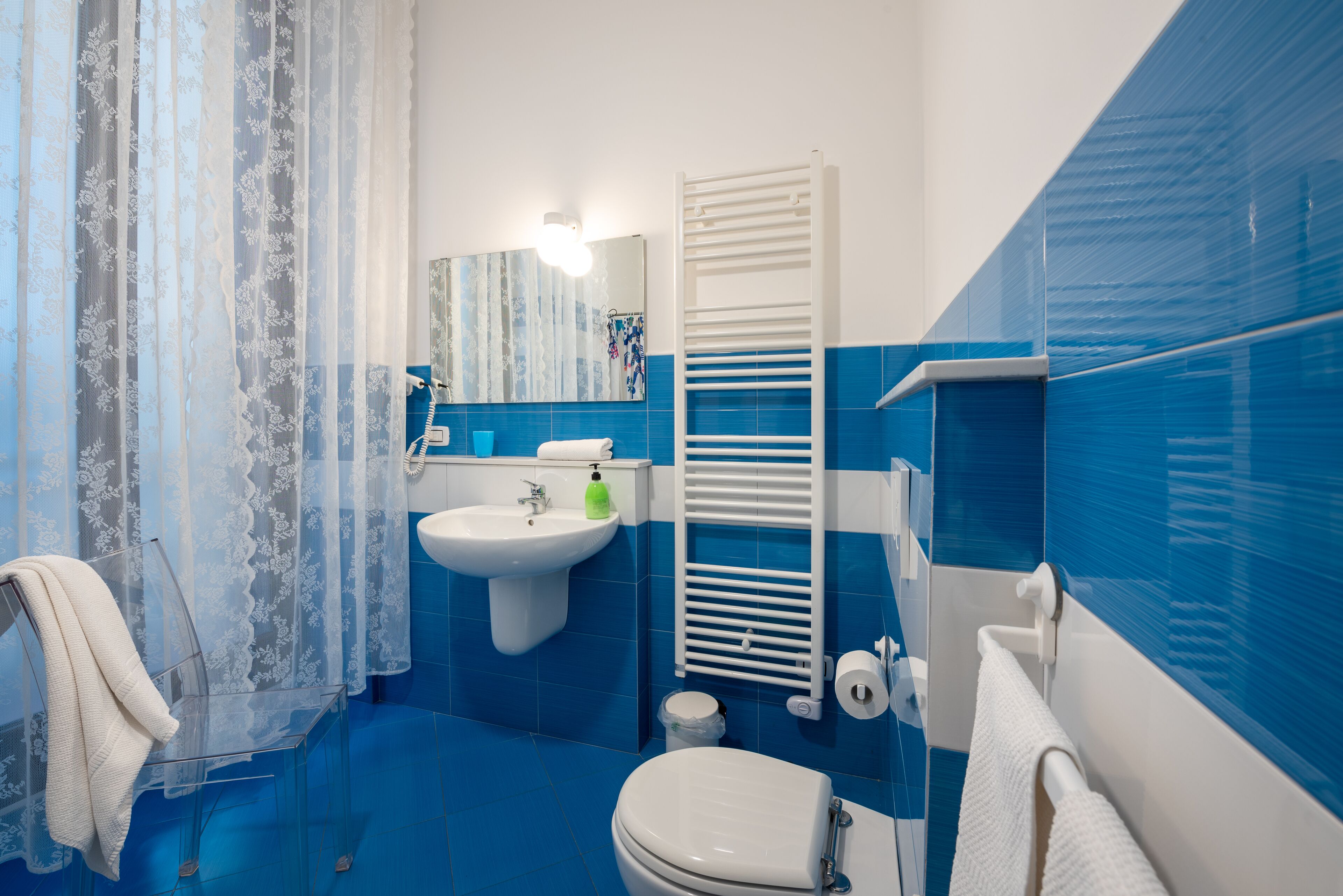 Ein Badezimmer mit Waschbecken, Toilette und Handtuchhalter.