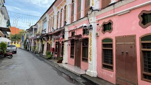A row of pink buildings with traditional architecture, including ornate decorations and large windows. - Sleep Sheep Phuket Hostel SHA (Phuket)