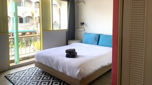 A bedroom with a bed, a bedside table, a window, and a view of the outside. - Sleep Sheep Phuket Hostel SHA (Phuket)