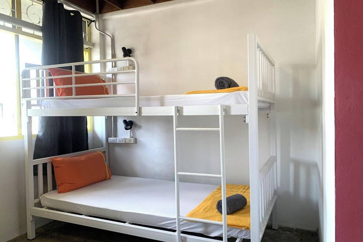 A bunk bed with two levels, each with pillows and a blanket.