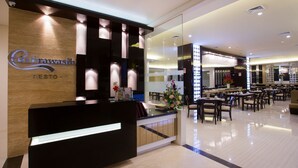 A hotel reception area with a modern design, featuring a reception desk, seating area, and a dining section.